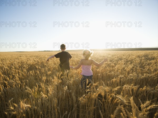 Children running through tall wheat field. Date : 2008