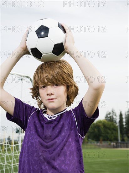 Portrait of boy holding soccer ball on head. Date: 2008