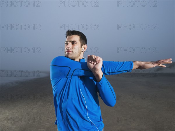 Man stretching on beach. Date: 2008