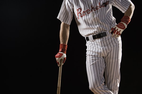 Midsection portrait of baseball player leaning on bat. Date: 2008