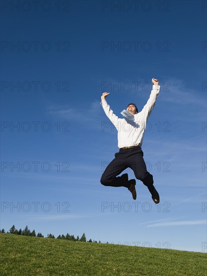 Businessman jumping in air.