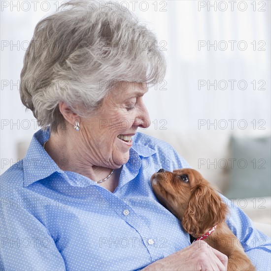 Senior woman hugging puppy.