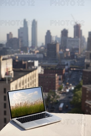 A computer in the city with an image of a countryside