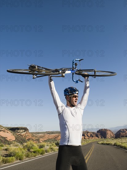 Biker on the road holding bike up