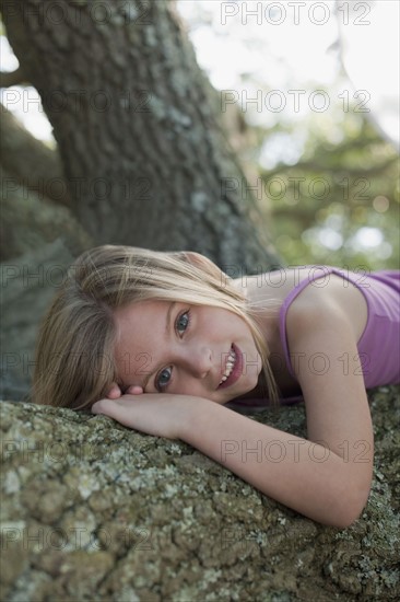 Girl lying down on tree