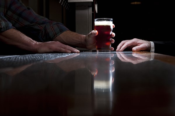 Bartender serving a beer. Photographer: Dan Bannister