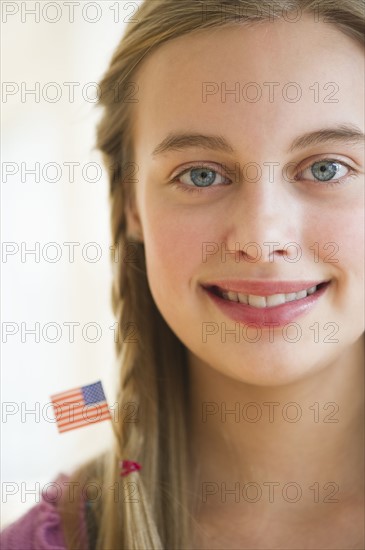 Young girl with American flag in hair.