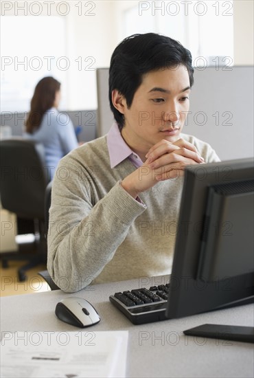 Man working in cubicle. - Photo12-Tetra Images