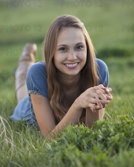 Beautiful long haired woman relaxing on the grass. Photo : Mike Kemp