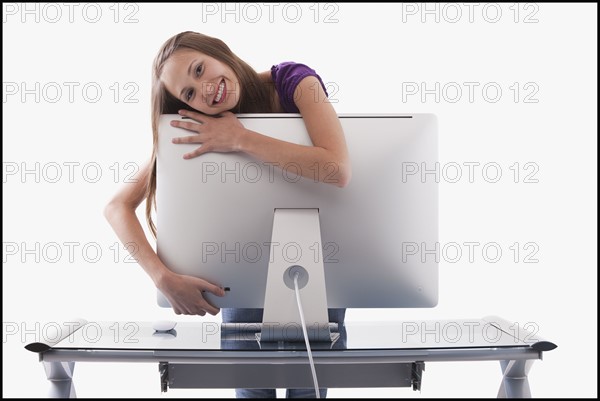 Happy woman hugging a computer monitor. Photo : Mike Kemp