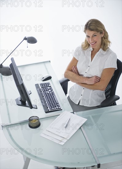 Confident businesswoman sitting at modern desk.