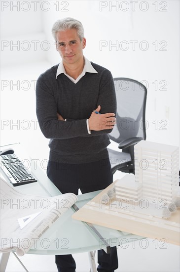 Architect standing behind his desk.