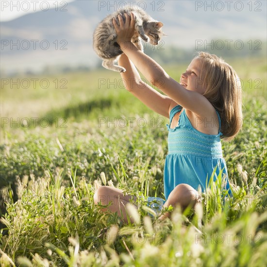 Young girl holding a kitten. Photo : Mike Kemp