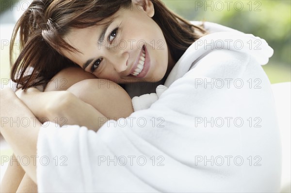 Smiling brunette woman wearing a bathrobe. Photo : momentimages