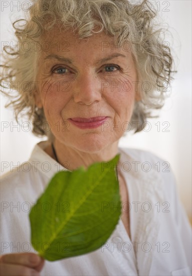 Woman holding a green leaf. Photo : Daniel Grill