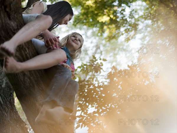 Two girls sitting in a tree. Photo : Tim Pannell