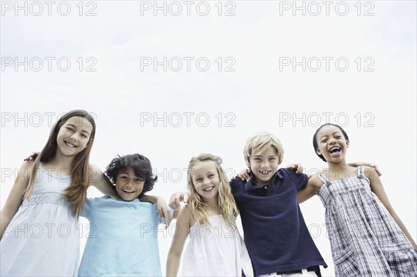 Young children with their arms around one another. Photo : momentimages