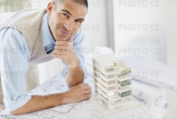 Portrait of architect with apartment model. Photo : Momentimages