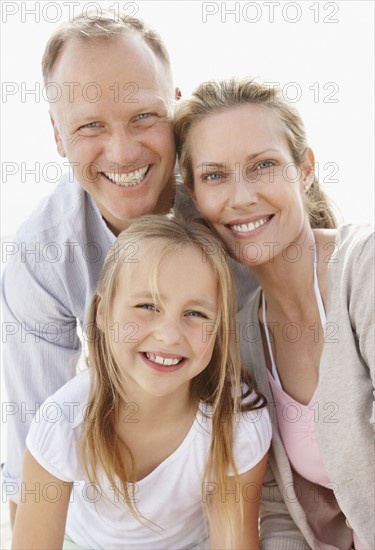 Girl (10-11) playing on beach with parents. Photo : Momentimages