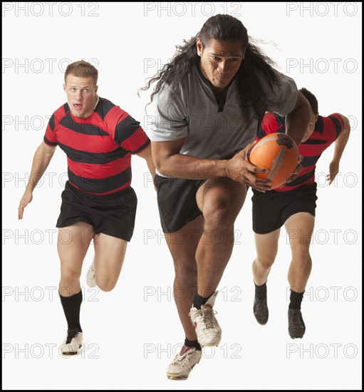 Rugby player running with ball, team chasing. Photo : Mike Kemp