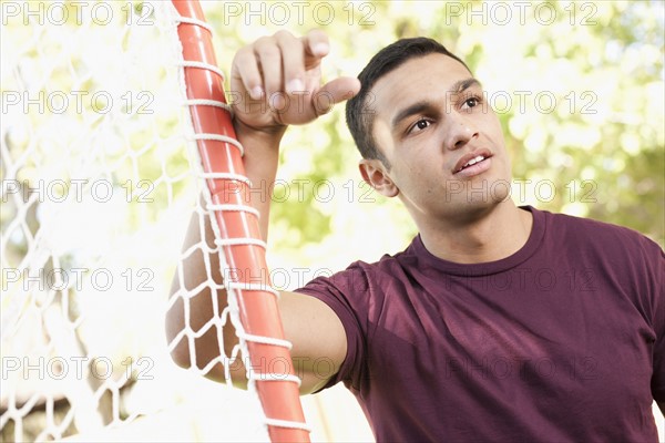 USA, Utah, young man leaning on goalpost. Photo : Tim Pannell