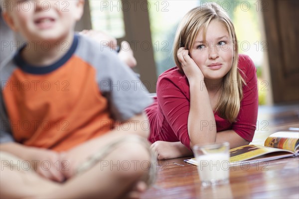 USA, Utah, Children (4-11) relaxing in home, girl reading book. Photo : Tim Pannell