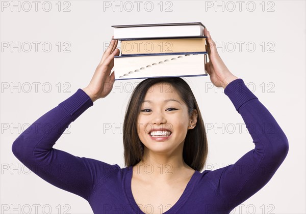 Female student carrying book on head. Photo : Dan Bannister