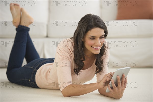 Woman lying on floor using palmtop.