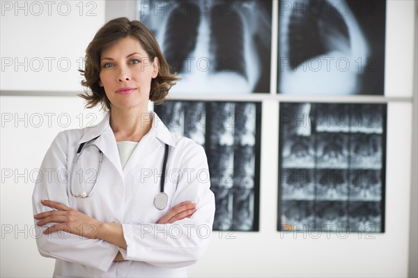 Portrait of doctor with x-ray images in background.