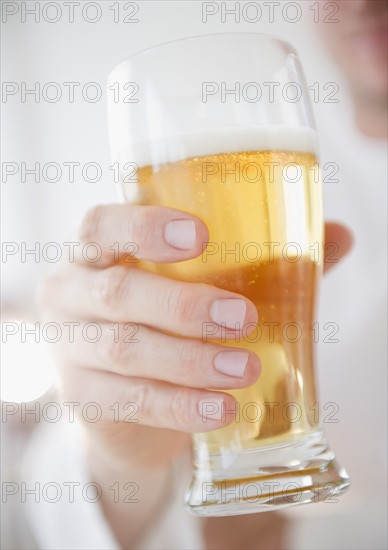 Hand holding glass of beer. Photo: Jamie Grill Photography