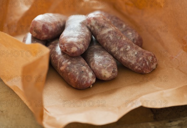 Studio shot of sausage wrapped in brown paper.