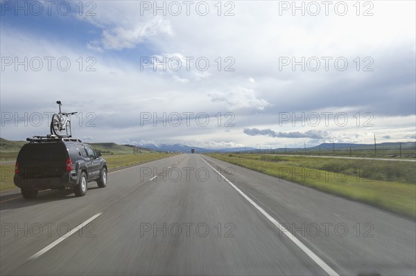 USA, Montana, Car driving down rural highway. Photo: Noah Clayton