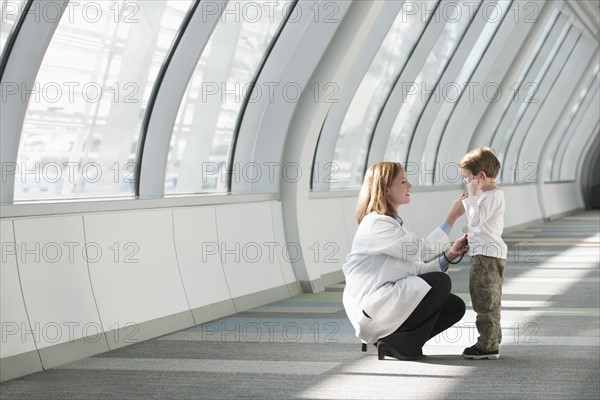 Female doctor talking to boy (6-7) in corridor. Photo: Mark Edward Atkinson