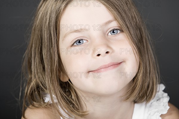 Studio portrait of smiling girl (6-7). Photo : Justin Paget