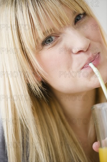 Young woman drinking juice. Photo: Jamie Grill Photography