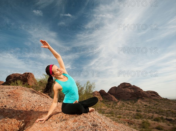 USA, Arizona, Phoenix, Young woman practicing yoga on desert.