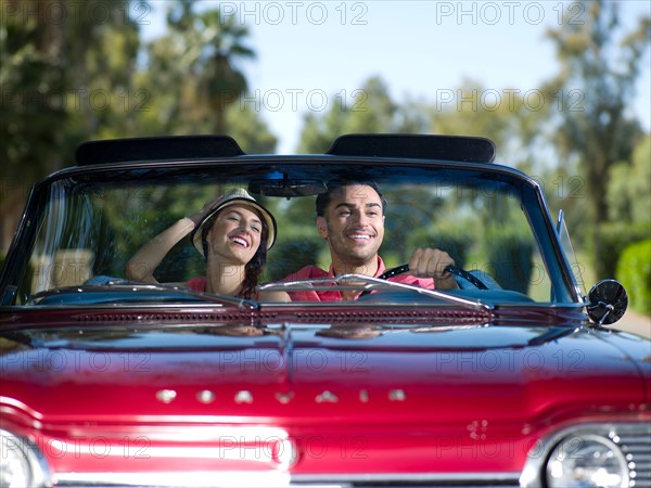 Young couple driving convertible car. Photo: db2stock