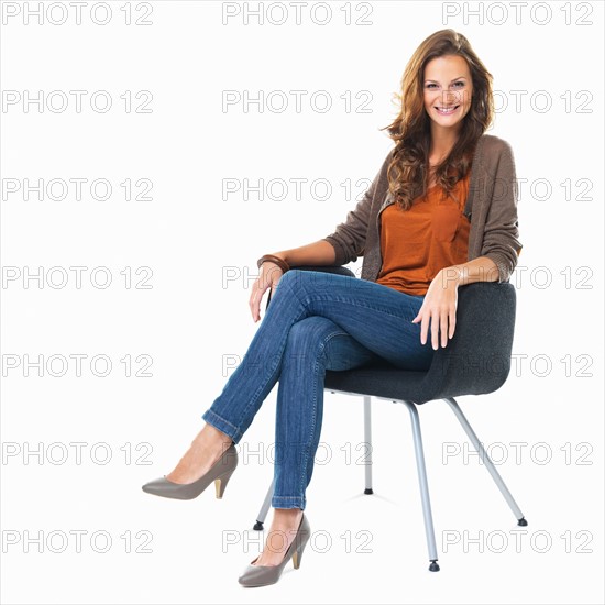 Studio shot of young woman sitting in chair. Photo: momentimages