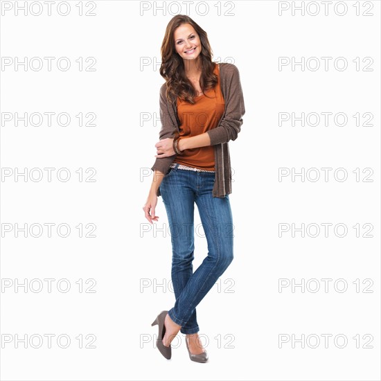 Studio shot of young attractive woman standing on white background and smiling. Photo: momentimages