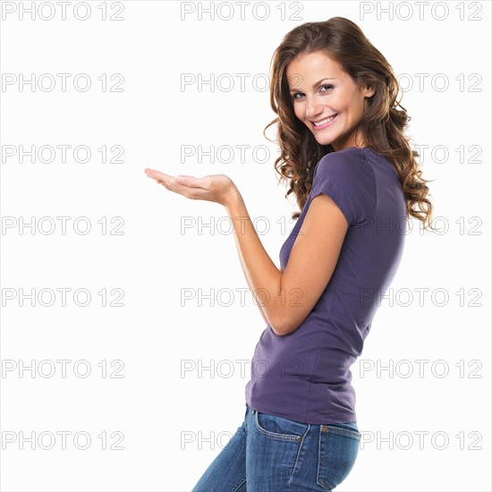 Studio portrait of attractive young woman gesturing and smiling. Photo: momentimages