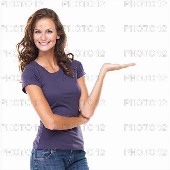 Studio portrait of attractive young woman gesturing and smiling. Photo : momentimages