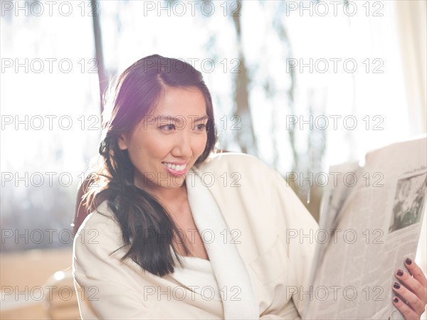 Woman reading newspaper in hotel. Photo : db2stock