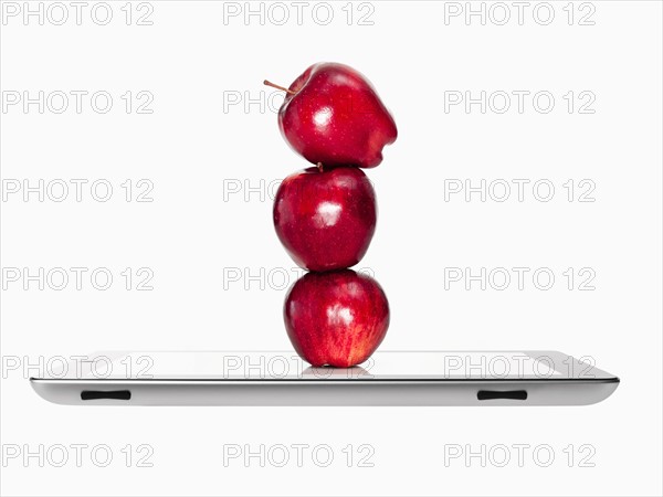 Apples on top of each other on digital tablet, studio shot. Photo: David Arky