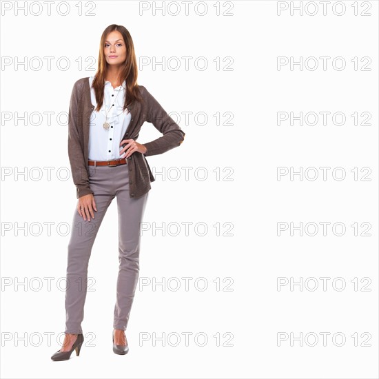 Studio shot of attractive sarcastic business woman standing with hand on hip. Photo: momentimages