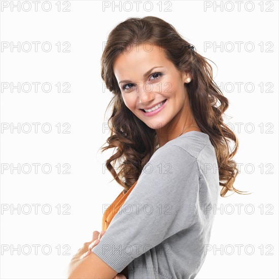 Studio portrait of happy smiling woman with hands folded. Photo: momentimages
