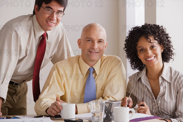 Portrait of smiling business people at meeting. Photo : Rob Lewine