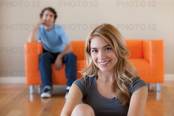 Young couple in room, focus on woman in foreground. Photo: Rob Lewine