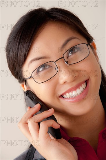 Studio portrait of businesswoman talking on cell phone. Photo: Rob Lewine