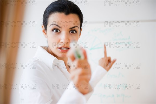 Businesswoman pointing during business meeting. Photo : Jamie Grill