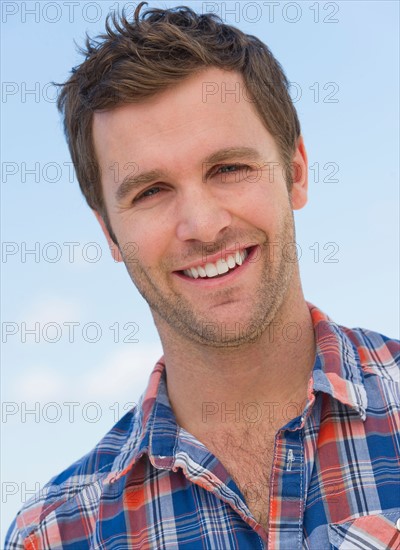 Portrait of mid adult man against blue sky.